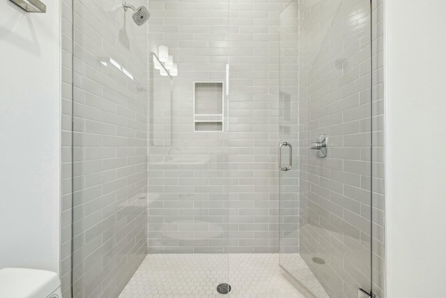 bathroom featuring a shower stall and toilet