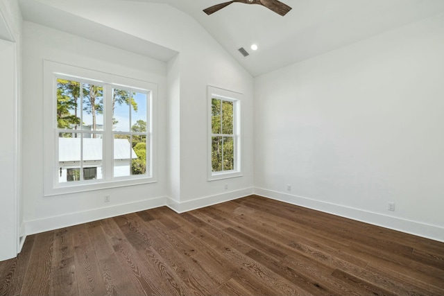 spare room with lofted ceiling, a healthy amount of sunlight, visible vents, and dark wood finished floors