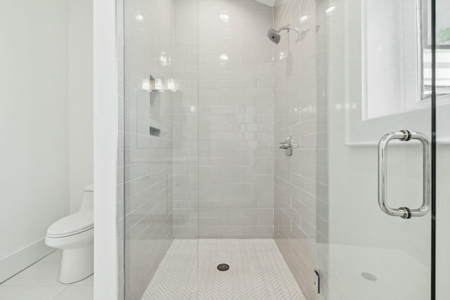 full bath featuring tile patterned floors, toilet, and a shower stall