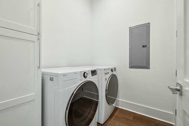 laundry area with dark wood-style flooring, separate washer and dryer, electric panel, laundry area, and baseboards