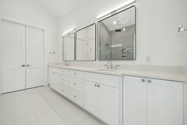 bathroom featuring tile patterned floors, a shower stall, double vanity, and a sink