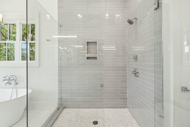 bathroom featuring a freestanding tub and a shower stall