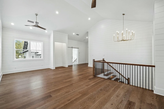 unfurnished living room featuring lofted ceiling, wood finished floors, a barn door, and ceiling fan with notable chandelier