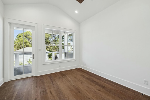 unfurnished room featuring a healthy amount of sunlight, dark wood-style floors, vaulted ceiling, and baseboards