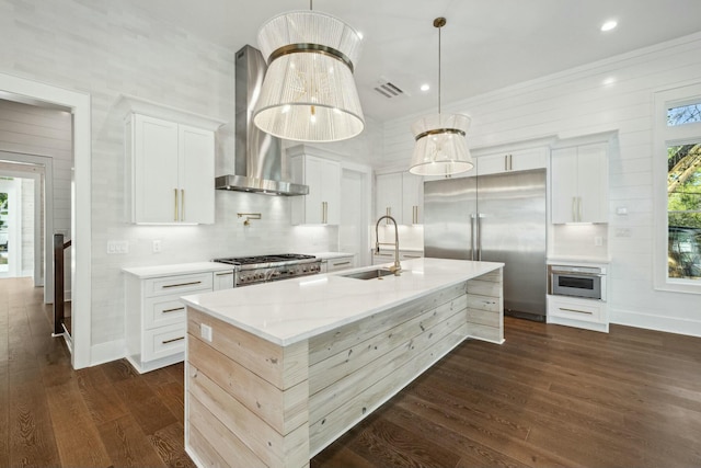 kitchen featuring a sink, dark wood-style flooring, visible vents, wall chimney range hood, and appliances with stainless steel finishes