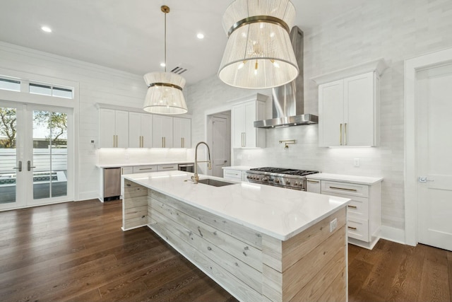 kitchen featuring a sink, tasteful backsplash, dark wood-type flooring, a spacious island, and wall chimney range hood
