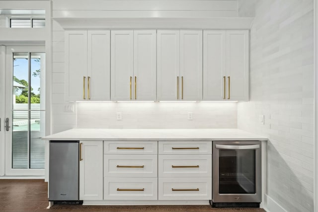 bar featuring beverage cooler, decorative backsplash, and dark wood-style flooring