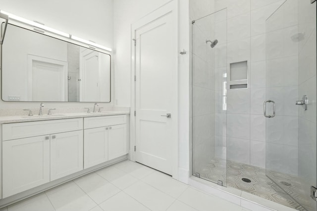 full bathroom with tile patterned floors, a shower stall, double vanity, and a sink