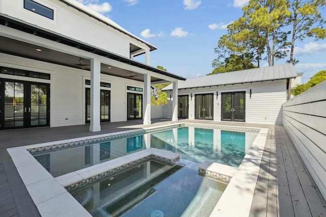 view of pool with french doors, ceiling fan, a pool with connected hot tub, and a patio area