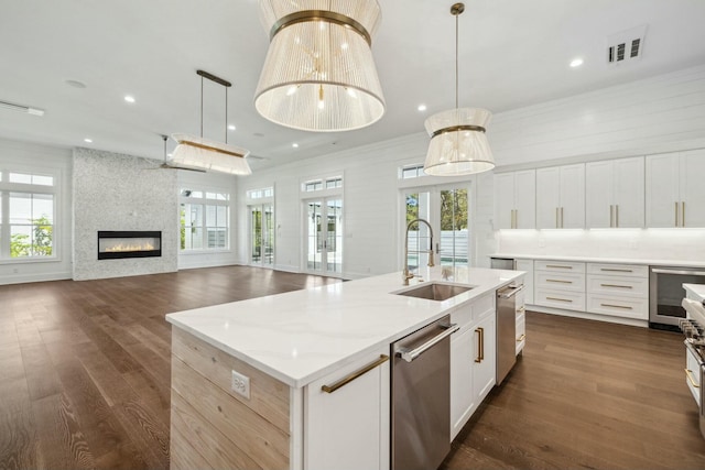 kitchen featuring stainless steel dishwasher, plenty of natural light, a sink, visible vents, and wine cooler