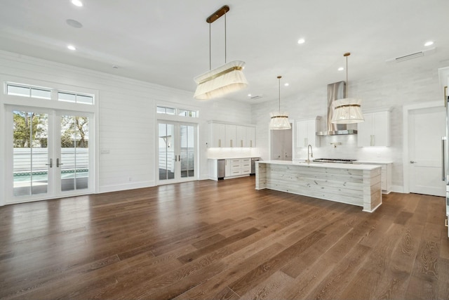 kitchen with dark wood-style flooring, french doors, light countertops, and wall chimney exhaust hood