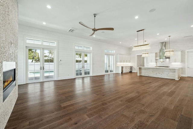 unfurnished living room featuring recessed lighting, a healthy amount of sunlight, and french doors