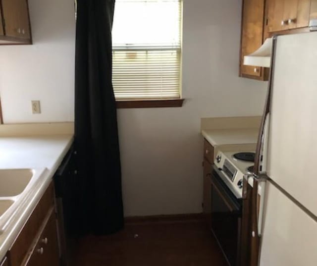 kitchen featuring range with electric stovetop, freestanding refrigerator, under cabinet range hood, and light countertops