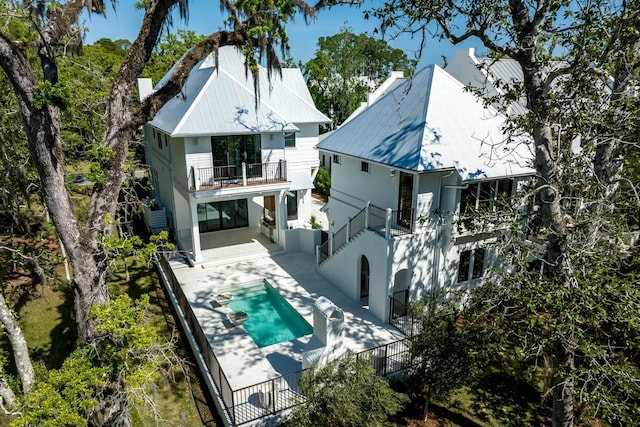 back of property with a patio area, a balcony, a fenced in pool, a fenced backyard, and stucco siding