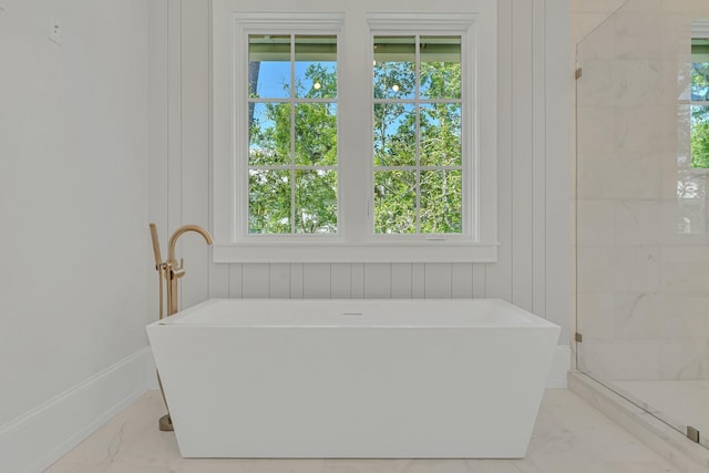 bathroom with a stall shower, a soaking tub, and marble finish floor