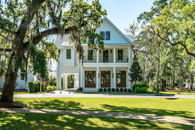 neoclassical / greek revival house featuring a balcony, french doors, and a front lawn