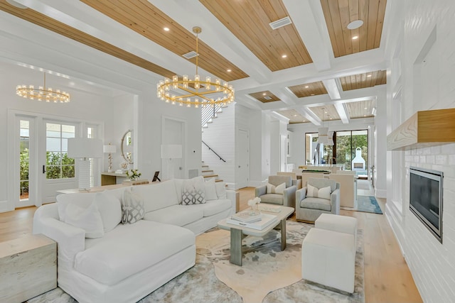living room with beamed ceiling, recessed lighting, stairway, a chandelier, and light wood-style floors