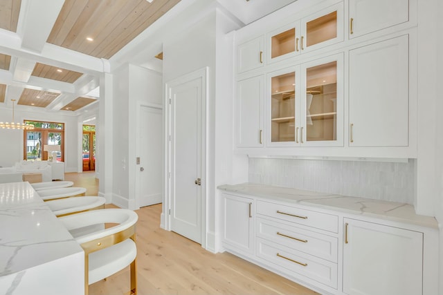 interior space featuring beamed ceiling, recessed lighting, decorative backsplash, light wood-style flooring, and wood ceiling
