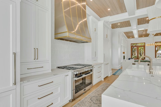 kitchen featuring tasteful backsplash, recessed lighting, double oven range, a sink, and premium range hood