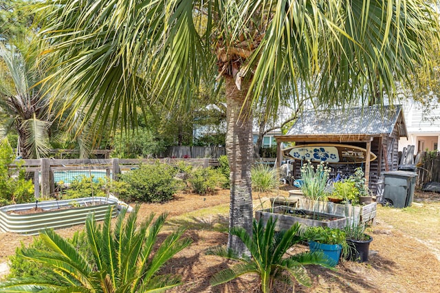 view of yard featuring fence and a vegetable garden