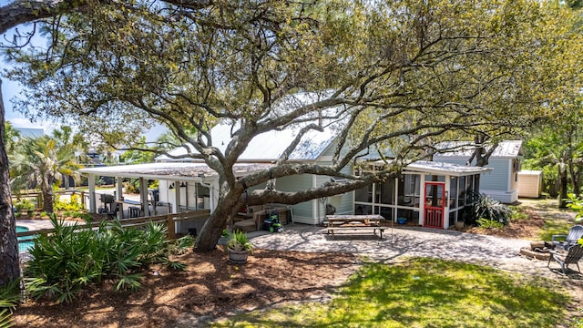 rear view of property with a sunroom and a patio