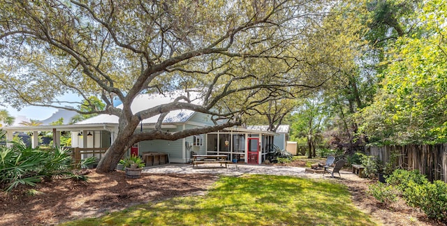 back of property with an outdoor fire pit, fence, and a patio area
