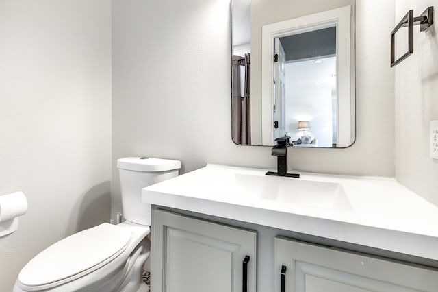 half bath featuring toilet and vanity