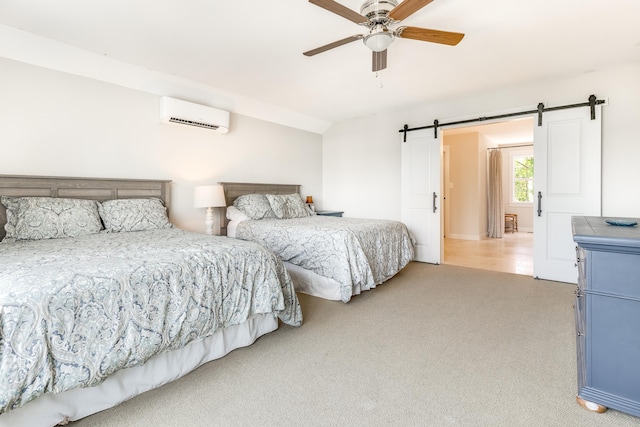 bedroom with a wall mounted air conditioner, carpet, a ceiling fan, and a barn door