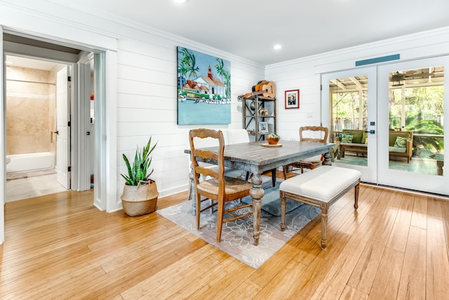 dining space with crown molding, french doors, and light wood finished floors