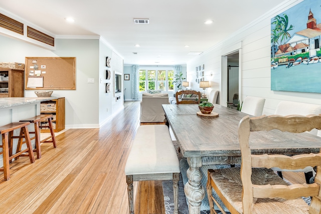dining room with visible vents, light wood-type flooring, recessed lighting, and ornamental molding