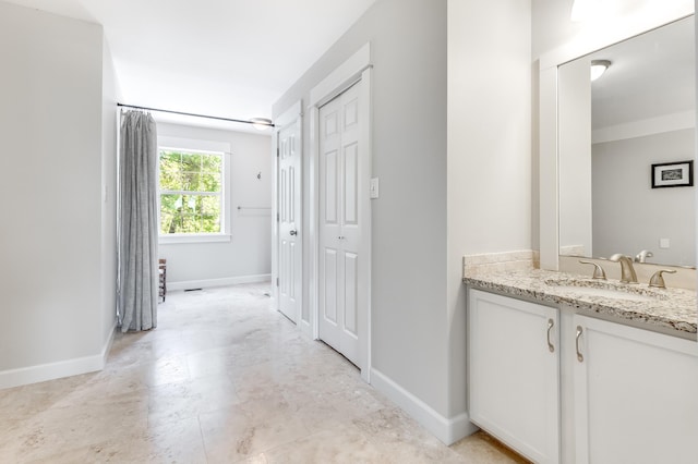 hallway with baseboards and a sink