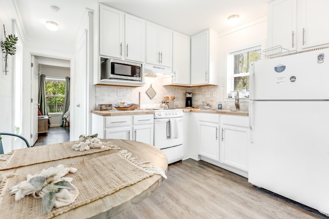 kitchen featuring white cabinetry, tasteful backsplash, under cabinet range hood, and white appliances