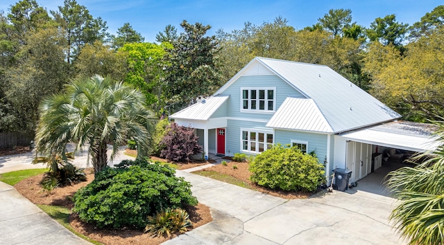 view of front of house featuring metal roof, concrete driveway, and an attached carport