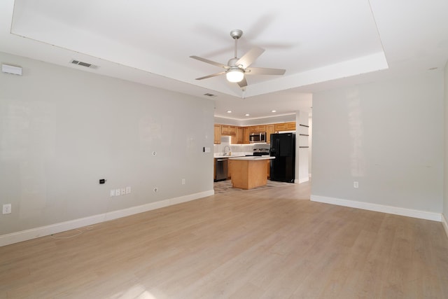 unfurnished living room featuring visible vents, light wood finished floors, ceiling fan, and baseboards