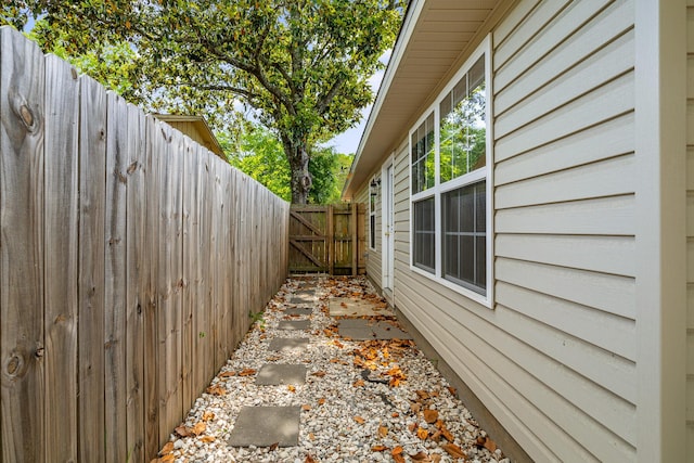 view of side of home featuring fence and a gate
