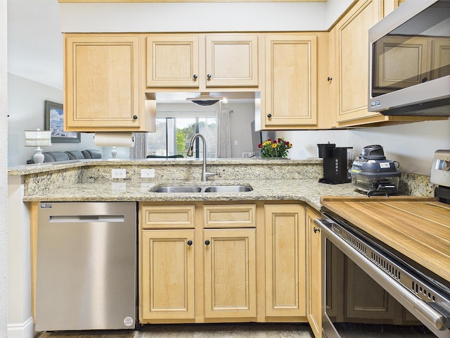 210 Southlake Ct Unit 210, Niceville, FL 32578 - kitchen featuring appliances with stainless steel finishes, a sink, light brown cabinets, and light stone counters