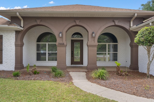 7008 Turnberry Cir, Navarre, FL 32566 - property entrance with roof with shingles, a yard, and brick siding