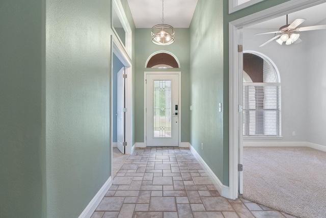 7008 Turnberry Cir, Navarre, FL 32566 - foyer featuring stone tile flooring, a textured wall, a notable chandelier, and baseboards