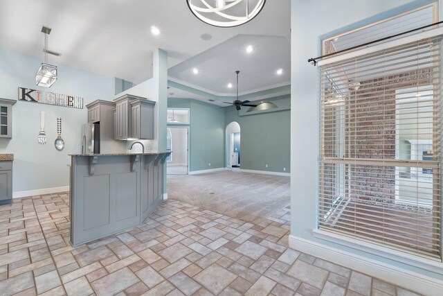 7008 Turnberry Cir, Navarre, FL 32566 - kitchen featuring gray cabinets, arched walkways, freestanding refrigerator, a breakfast bar area, and baseboards