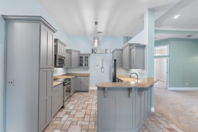 7008 Turnberry Cir, Navarre, FL 32566 - kitchen with gray cabinetry, a peninsula, a breakfast bar area, and appliances with stainless steel finishes