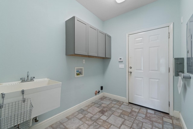 7008 Turnberry Cir, Navarre, FL 32566 - laundry area with a sink, cabinet space, washer hookup, baseboards, and brick floor