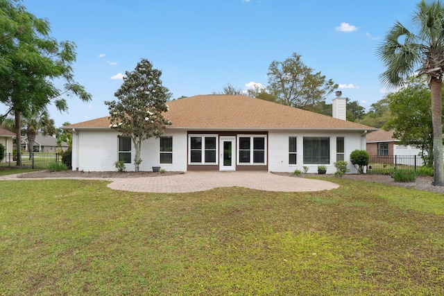 7008 Turnberry Cir, Navarre, FL 32566 - rear view of house featuring a chimney, brick siding, fence, and a lawn