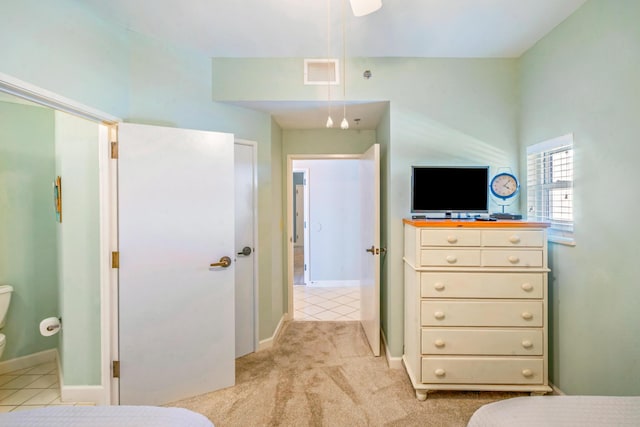 bedroom featuring visible vents, baseboards, light tile patterned flooring, and light colored carpet