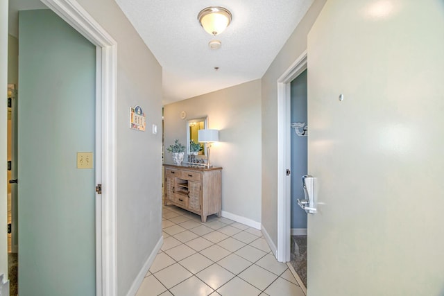 hallway with baseboards and light tile patterned floors