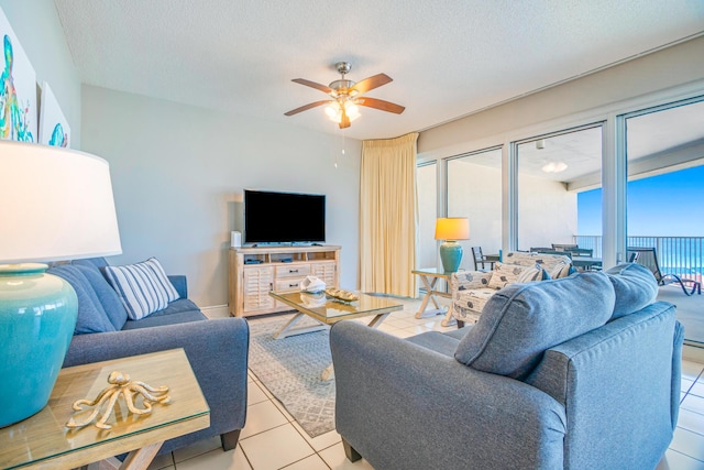 tiled living area featuring a ceiling fan and a textured ceiling