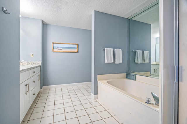 full bathroom with a garden tub, a textured ceiling, vanity, baseboards, and tile patterned floors