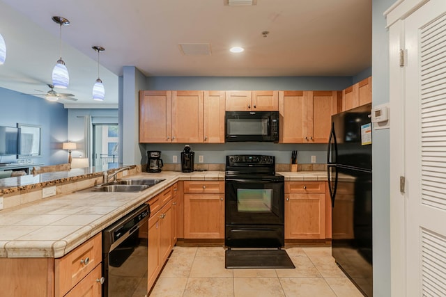 kitchen featuring a sink, black appliances, tile countertops, a peninsula, and a ceiling fan