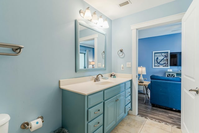 bathroom with toilet, tile patterned flooring, visible vents, and vanity