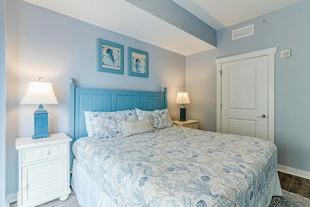 bedroom featuring visible vents, wood finished floors, and baseboards