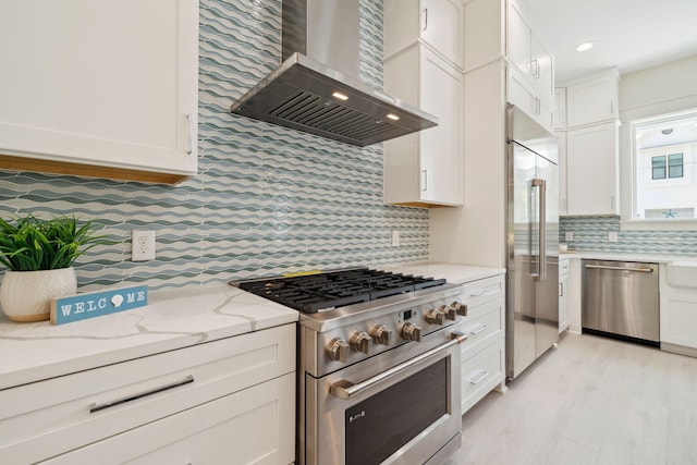 144 Dalton Dr, Santa Rosa Beach, FL 32459 - kitchen with light stone counters, decorative backsplash, high quality appliances, wall chimney range hood, and white cabinets